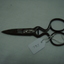 Scissors with wide blades and a brake between the two parts Showing the blades closed