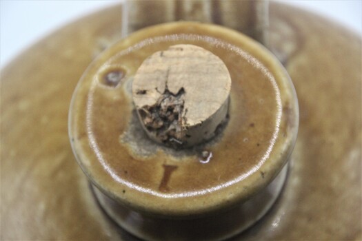close up of neck of pottery bottle with the Number "1" on lip