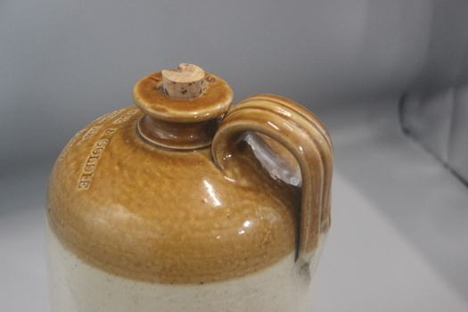 Close up of handle and neck of pottery bottle with brown coloured shoulder