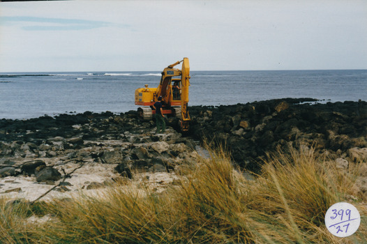 Mechanical digger working on rocks digging a drain for South Beach Estate