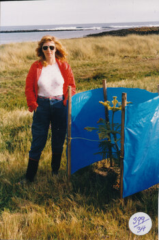Female standing by Norfolk Island Pine just planted