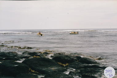 Choppy sea with two small boats, 3 fishermen working