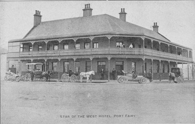 black and white photograph of 2 storied building with wrought iron lace verandahs with horse and carts and carriages outside