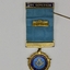 medal on blue grograin ribbon with a metal bar at top with a pin 