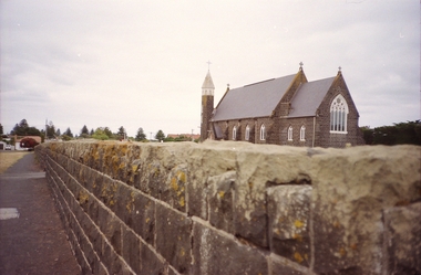 Catholic Church with spire showing bluestone fence facing Princes Highway