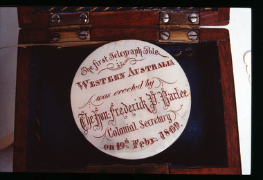 Engraved mother of pearl disc around which paper tape is wound, housed in a wooden presentation box.