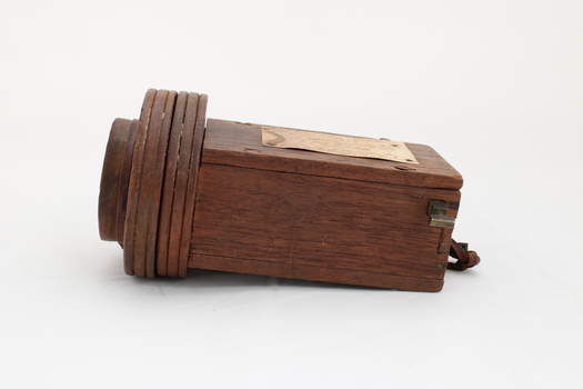 Wooden rectangular device with cone shaped speaker/microphone at one end.