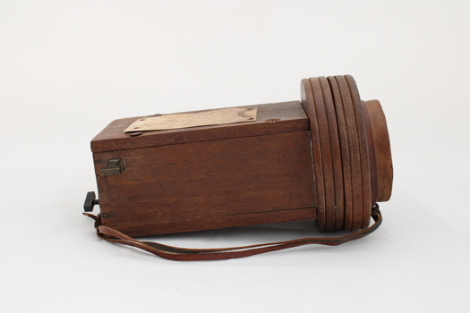 Wooden rectangular device with cone shaped speaker/microphone at one end.