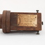 Wooden rectangular device with cone shaped speaker/microphone at one end.