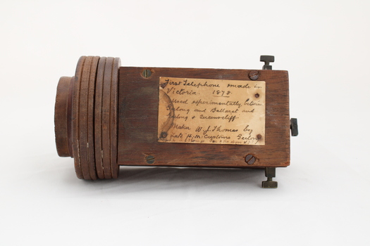 Wooden rectangular device with cone shaped speaker/microphone at one end.
