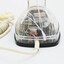 Clear plastic telephone with dial underneath long stemmed handle; colourful electrical wires visible within.