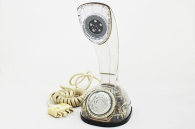 Clear plastic telephone with dial underneath long stemmed handle; colourful electrical wires visible within.