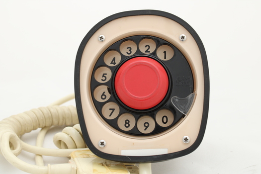 Clear plastic telephone with dial underneath long stemmed handle; colourful electrical wires visible within.