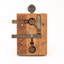 Metal device mounted on block of wood with handle that moves up and down via a spring.