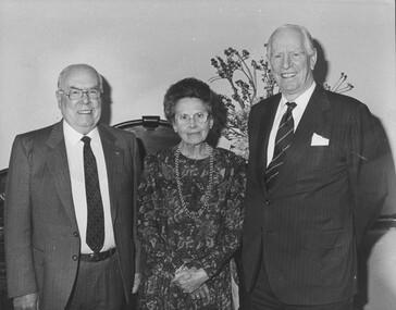 Two older man flank an older woman