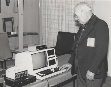 Man touches the keyboard of a computer with a voice output attached