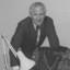 Badly photoshopped picture of John Cook with fake arm and missing head of woman writing on notepad