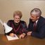 John Cook sitting next to a woman writing on a thickly lined notepad