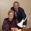 John Cook sitting next to a woman writing on a thickly lined notepad