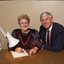 John Cook sitting next to a woman writing on a thickly lined notepad
