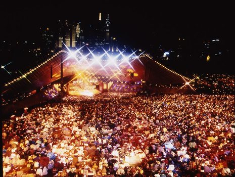 Melbourne city skyline at night with Myer Music Bowl and crowds