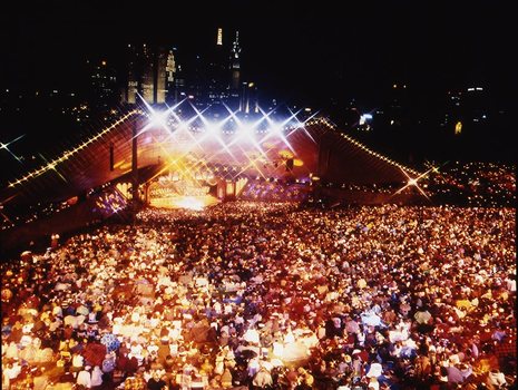 Melbourne city skyline at night with Myer Music Bowl and crowds