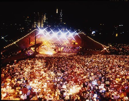 Melbourne city skyline at night with Myer Music Bowl and crowds