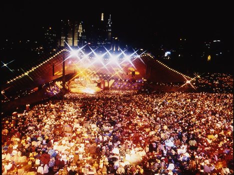 Melbourne city skyline at night with Myer Music Bowl and crowds