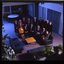 15 people sit around a small table and turn towards the photographer who is a floor above them