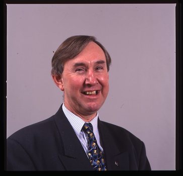 Portrait of man in blue suit, with striped shirt and AFB pin