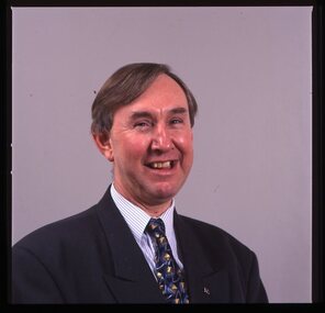 Portrait of man in blue suit, with striped shirt and AFB pin