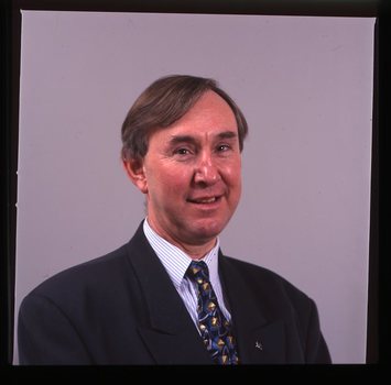 Portrait of man in blue suit, with striped shirt and AFB pin