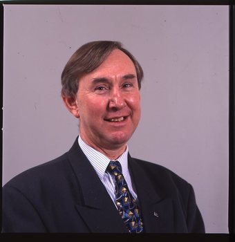 Portrait of man in blue suit, with striped shirt and AFB pin