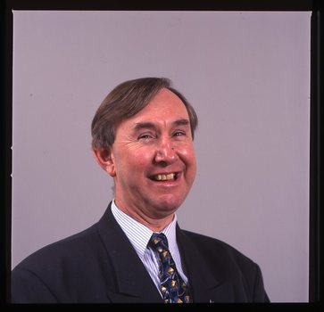 Portrait of man in blue suit, with striped shirt and AFB pin