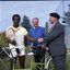 Bill Cosby dressed for tennis shaking Hubert Opperman's hand whilst Arthur Wilkins looks on