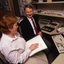 Robin Pleydell sits next to AFB Staff member at her workstation whilst she is reading Braille