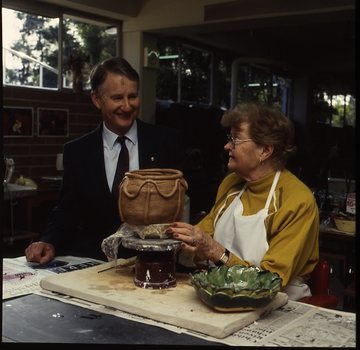 Robin Pleydell stands next to female client holding a clay bowl