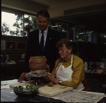 Robin Pleydell stands next to female client holding a clay bowl