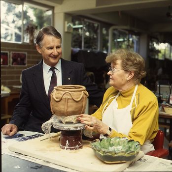 Robin Pleydell stands next to female client holding a clay bowl
