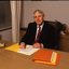John Cook sitting at his desk with pen in hand
