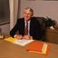 John Cook sitting at his desk with pen in hand