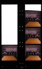 Group of people sit or stand behind a table with AFB sign in background
