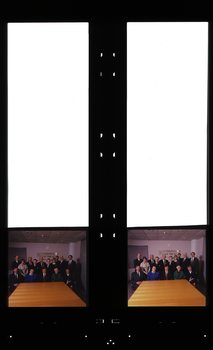 Group of people sit or stand behind a table with AFB sign in background
