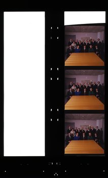 Group of people sit or stand behind a table with AFB sign in background