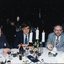 Three men sit at the as they wait for dessert to arrive
