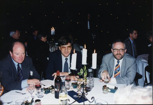 Three men sit at the as they wait for dessert to arrive