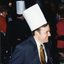 Profile of smiling man in a suit and wearing a paper chef's hat