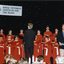 National Boys Choir dressed in red, with their conductor, in front of a starry backdrop with Peter Cupples
