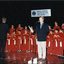 National Boys Choir dressed in red, with their conductor, in front of a starry backdrop with Peter Cupples