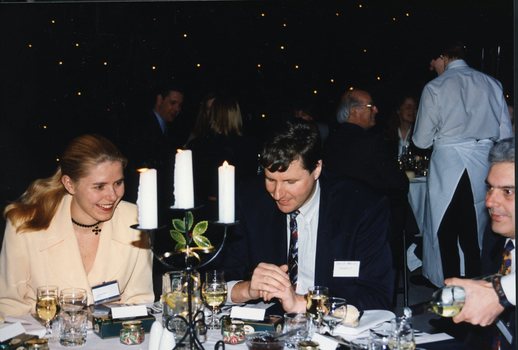 People at a table whilst a waiter pours wine